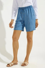 Front image of Coolibar enclave chambray shorts. Pull on light indigo shorts. 