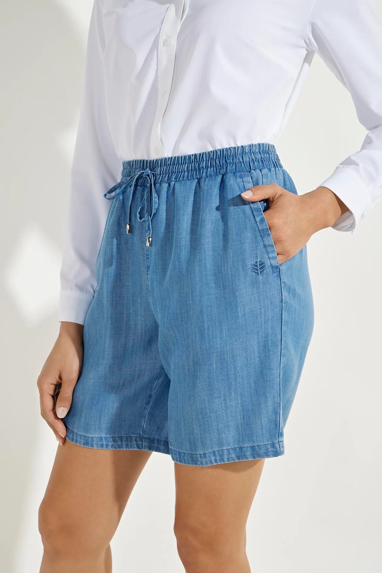 Front image of Coolibar enclave chambray shorts. Pull on light indigo shorts.