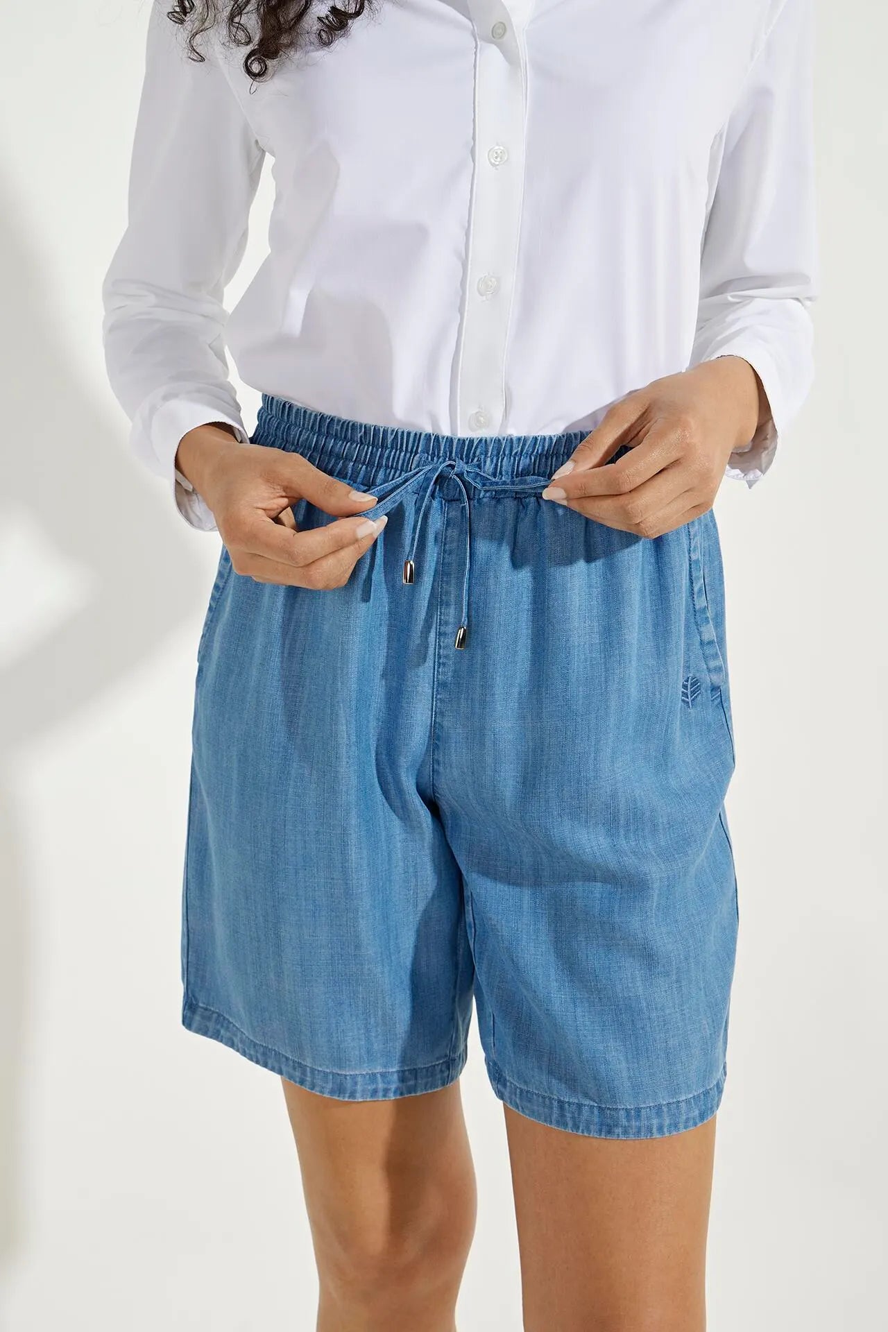 Front image of Coolibar enclave chambray shorts. Pull on light indigo shorts.