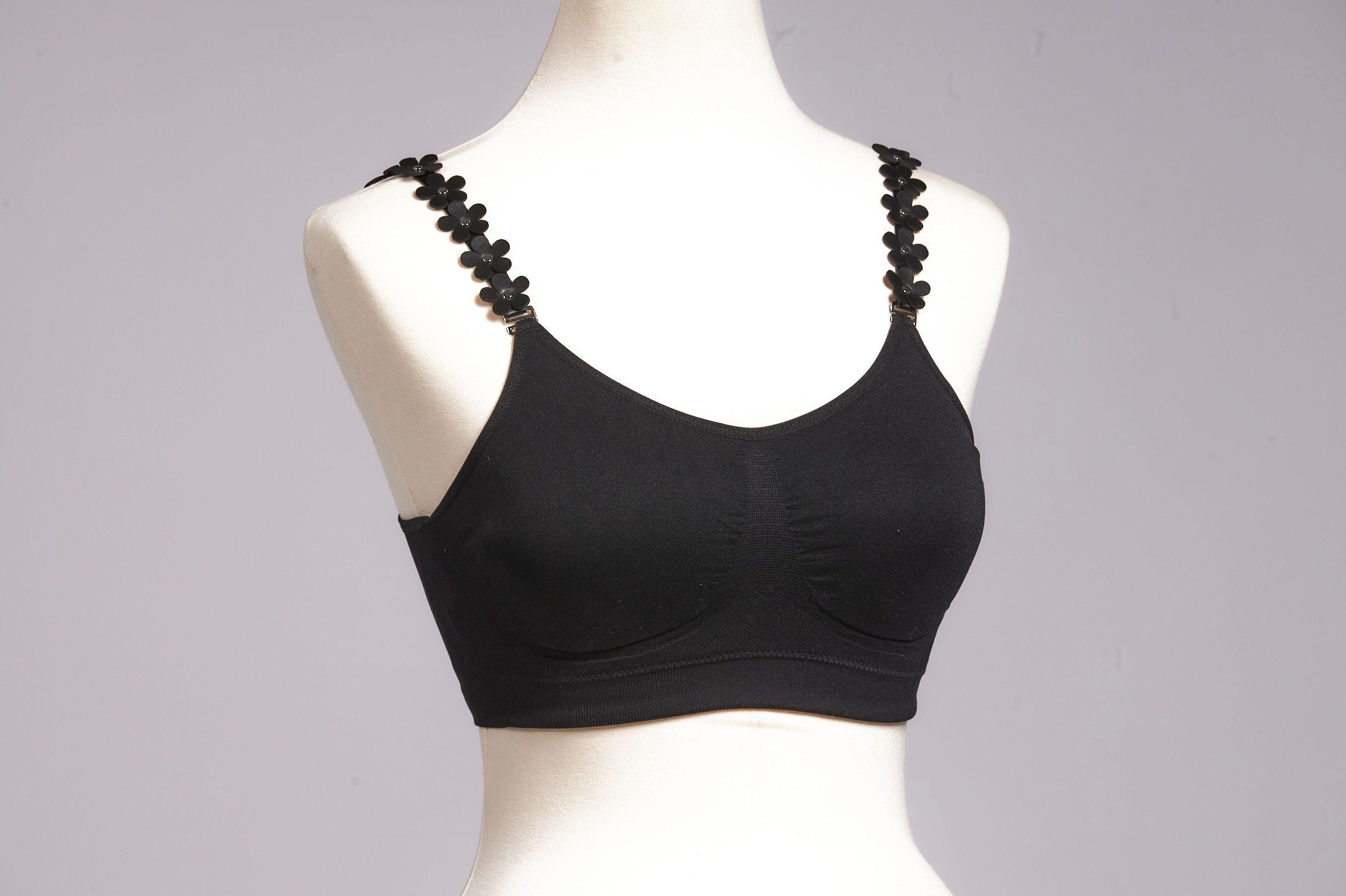 Front image of black strap its bra. Black vegan leather flower strap.