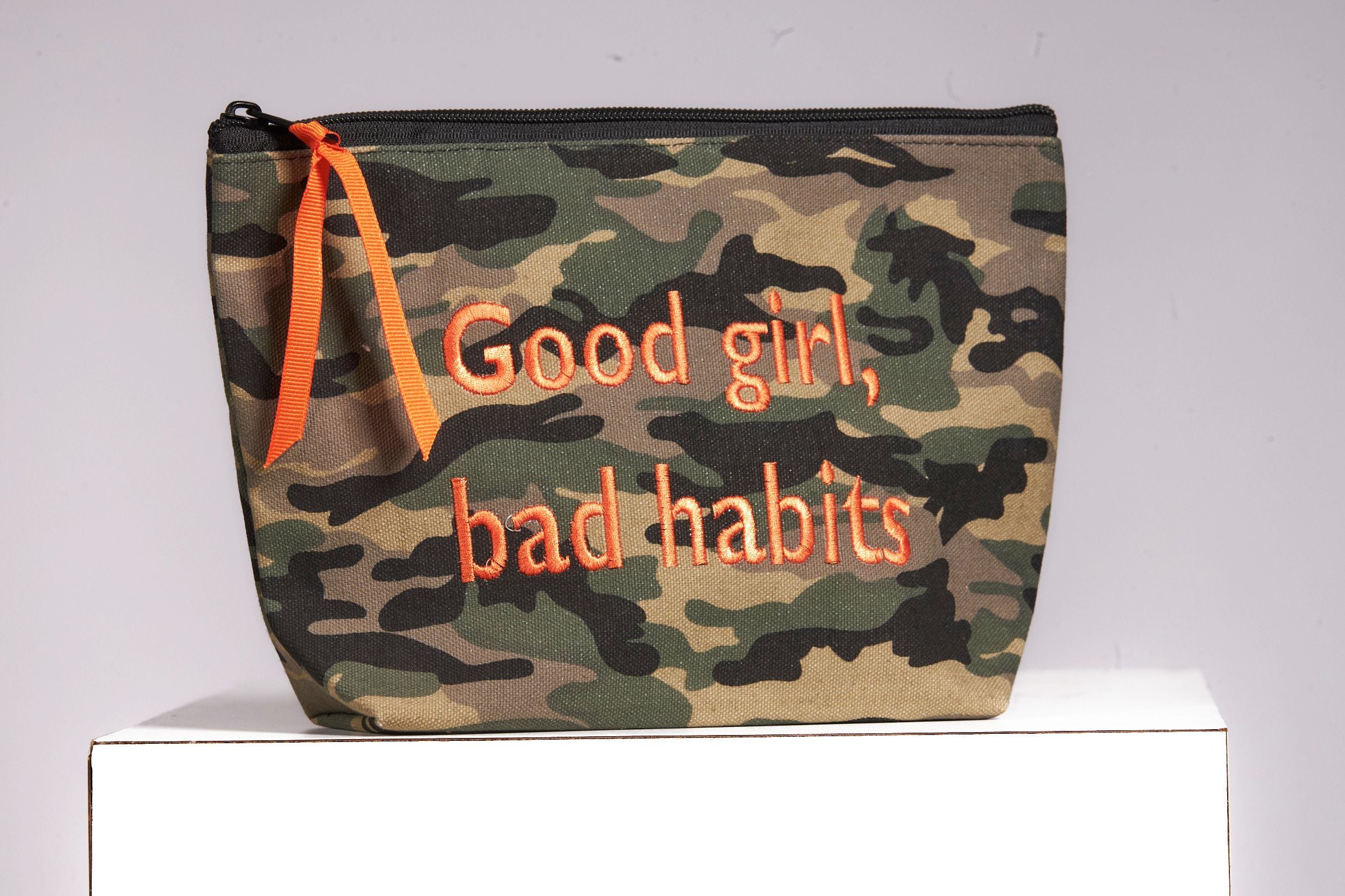 Front image of cosmetic bag. Good girl, bad habits.