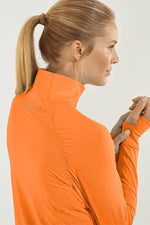 Back image of Coolibar arabella quarter zip pullover. Apricot orange top. 