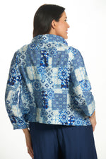 Back image of Shana short printed crushed jacket. Blue cowl neck top. 