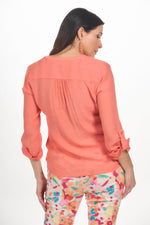 Back image of Elo button and tie front blouse in coral. 