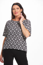 Front image of Mimozza Dolman sleeve relaxed top. Black and white feather printed top. 
