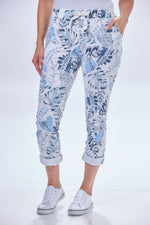 Front image of look mode tropical leaf jeggings. White floral printed pull on jeggings. 