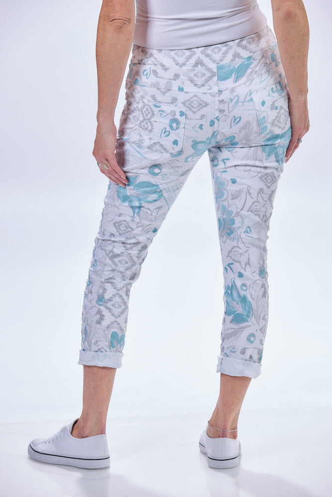 Back image of heart print pants. Pull on printed jeggings. White and blue printed pants. 