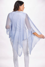 Back image of the magic scarf top. Lightweight knit ruana in light blue. 