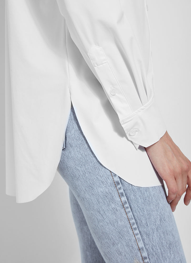 Curved hem view of Lysse schiffer button down shirt. White long sleeve top. 