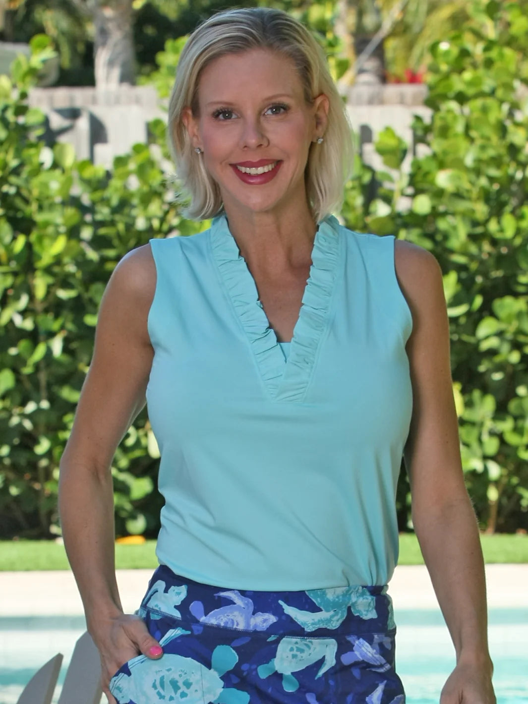 Front image of AnaClare Calla solid ruffle top. Aqua blue sleeveless ruffle top. 